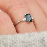 emerald cut blue teal sapphire trilogy engagement ring in platinum