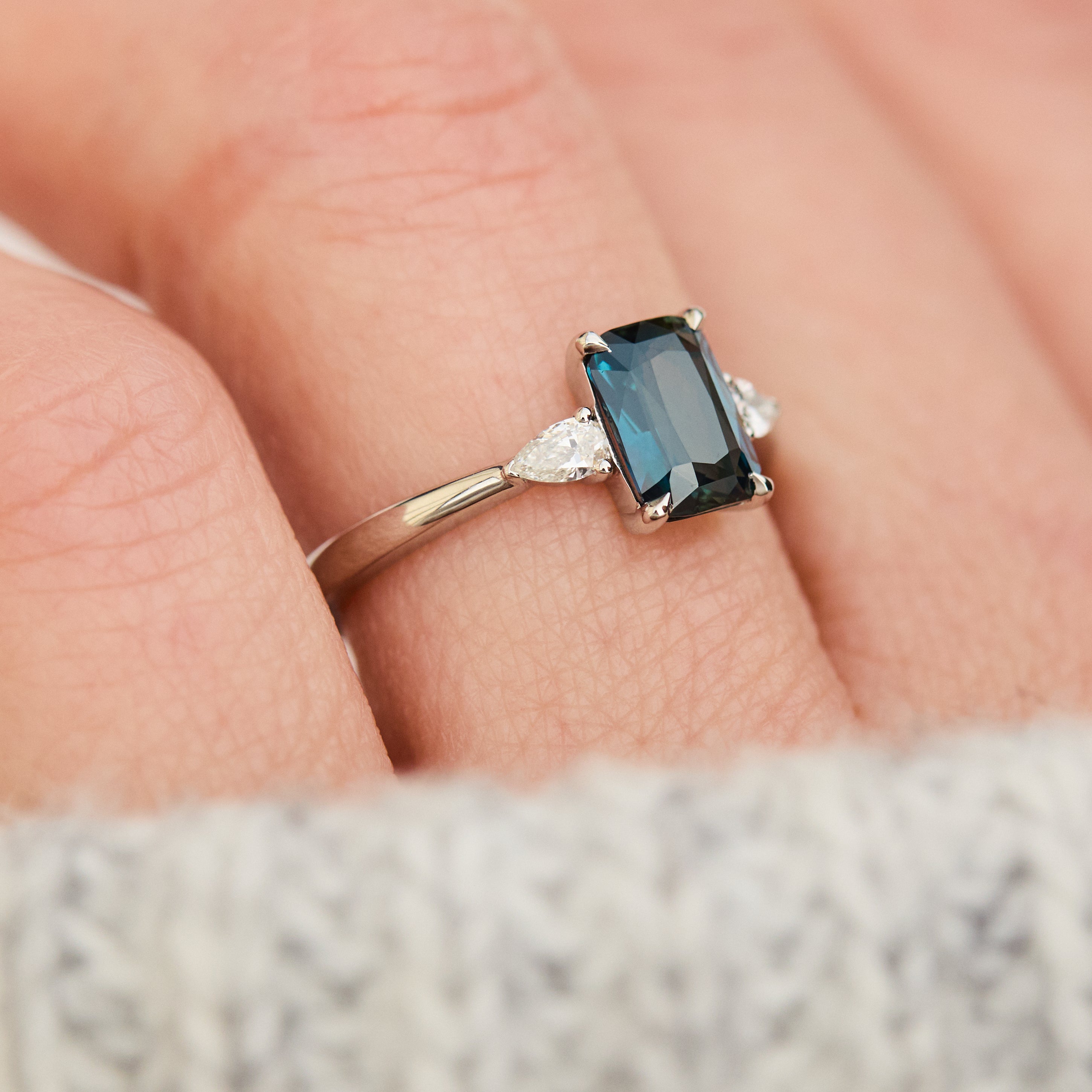 emerald cut blue teal sapphire trilogy engagement ring in platinum