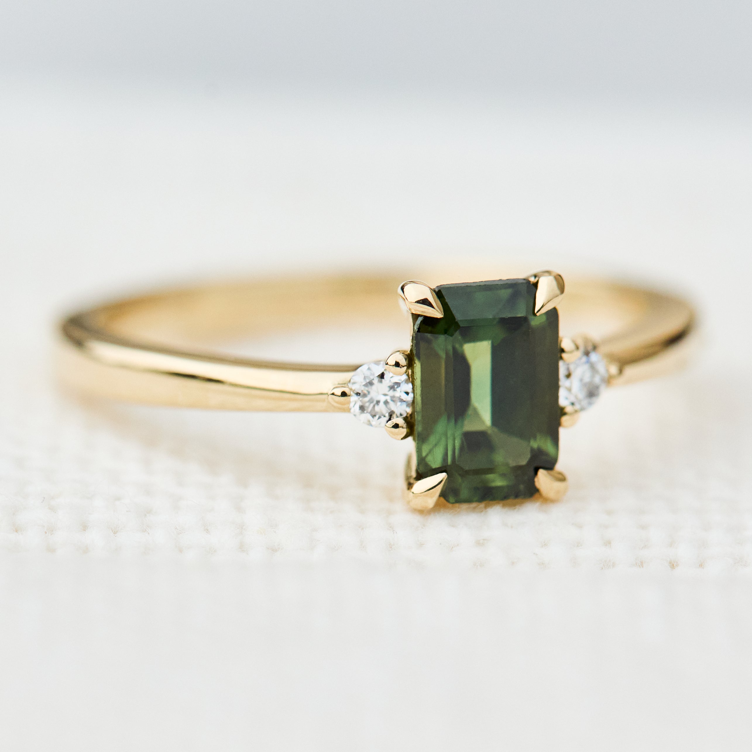 emerald cut green sapphire ring in yellow gold