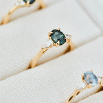 green teal oval sapphire ring in yellow gold