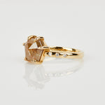 Hexagon-shaped diamond engagement ring with a gold band and round diamonds