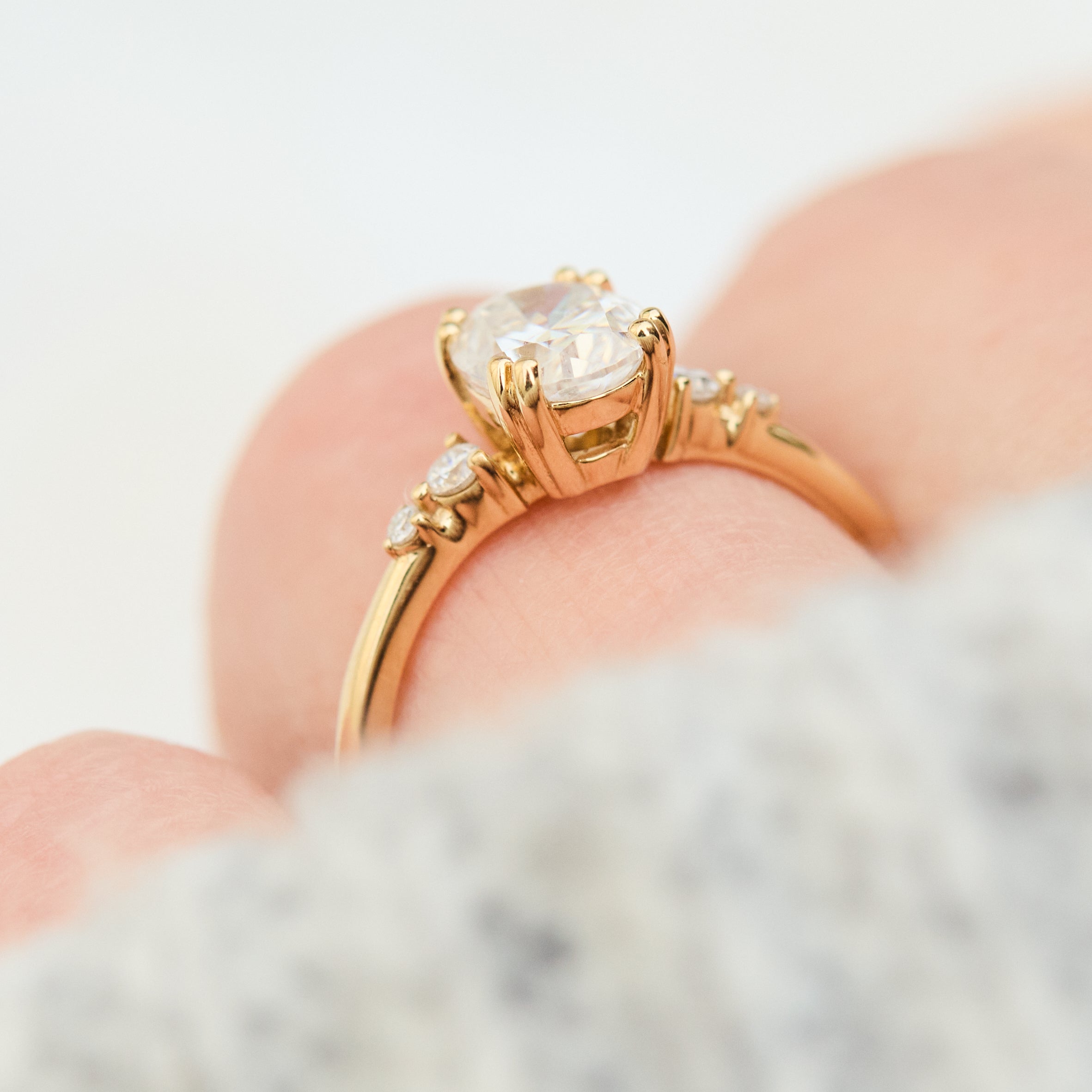cushion cut moissanite and diamond engagement ring in yellow gold