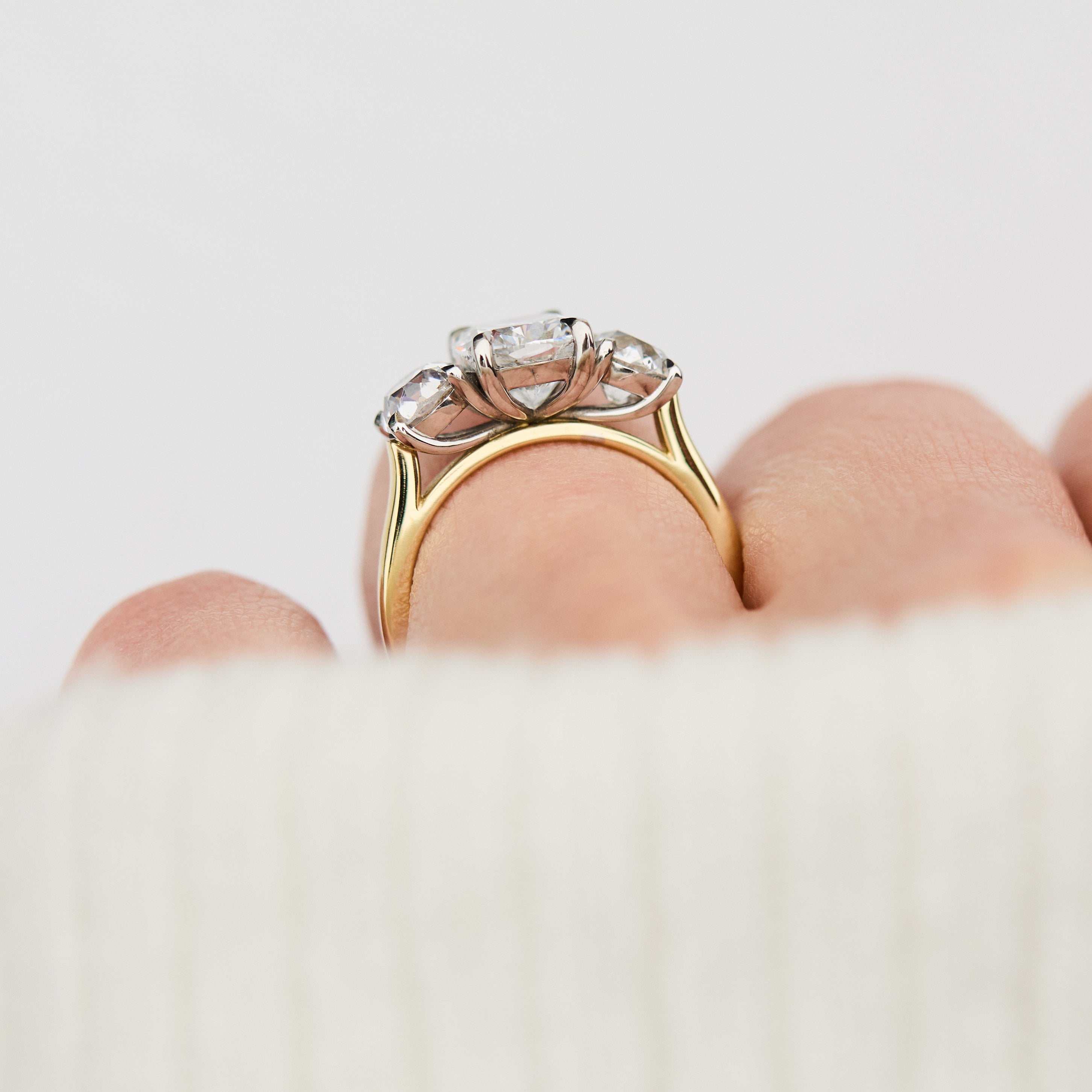 elongated cushion lab grown diamond trilogy engagement ring in yellow gold