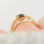 emerald cut teal sapphire trilogy engagement ring in yellow gold