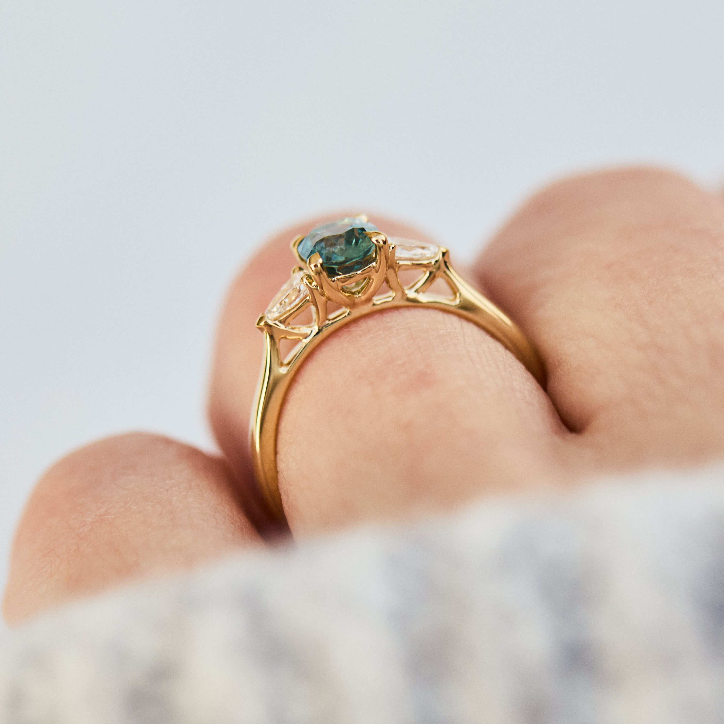 oval blue teal montana sapphire engagement ring in yellow gold