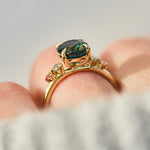 oval blue teal sapphire yellow gold engagement ring with four side stones