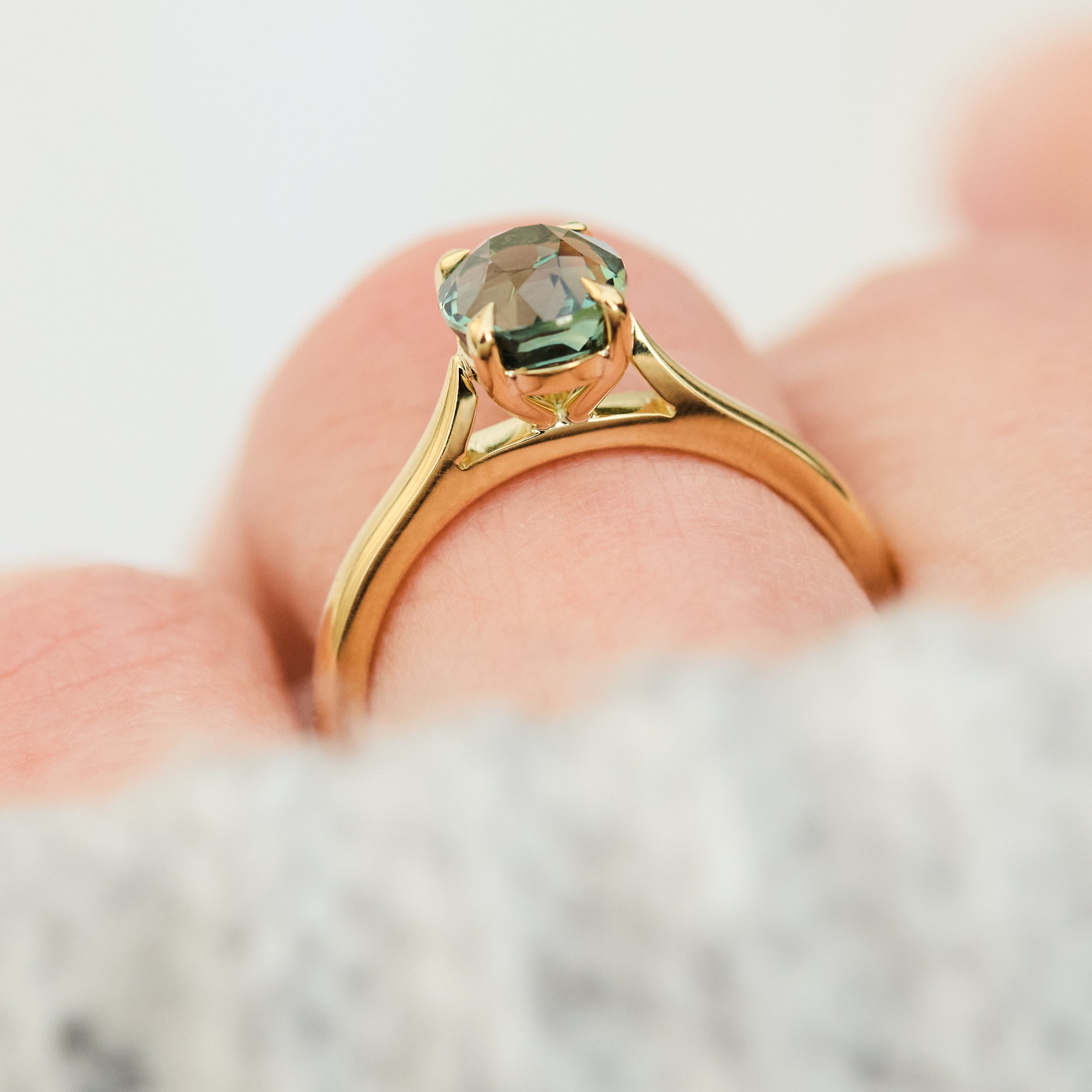 oval teal sapphire solitaire engagement ring in yellow gold