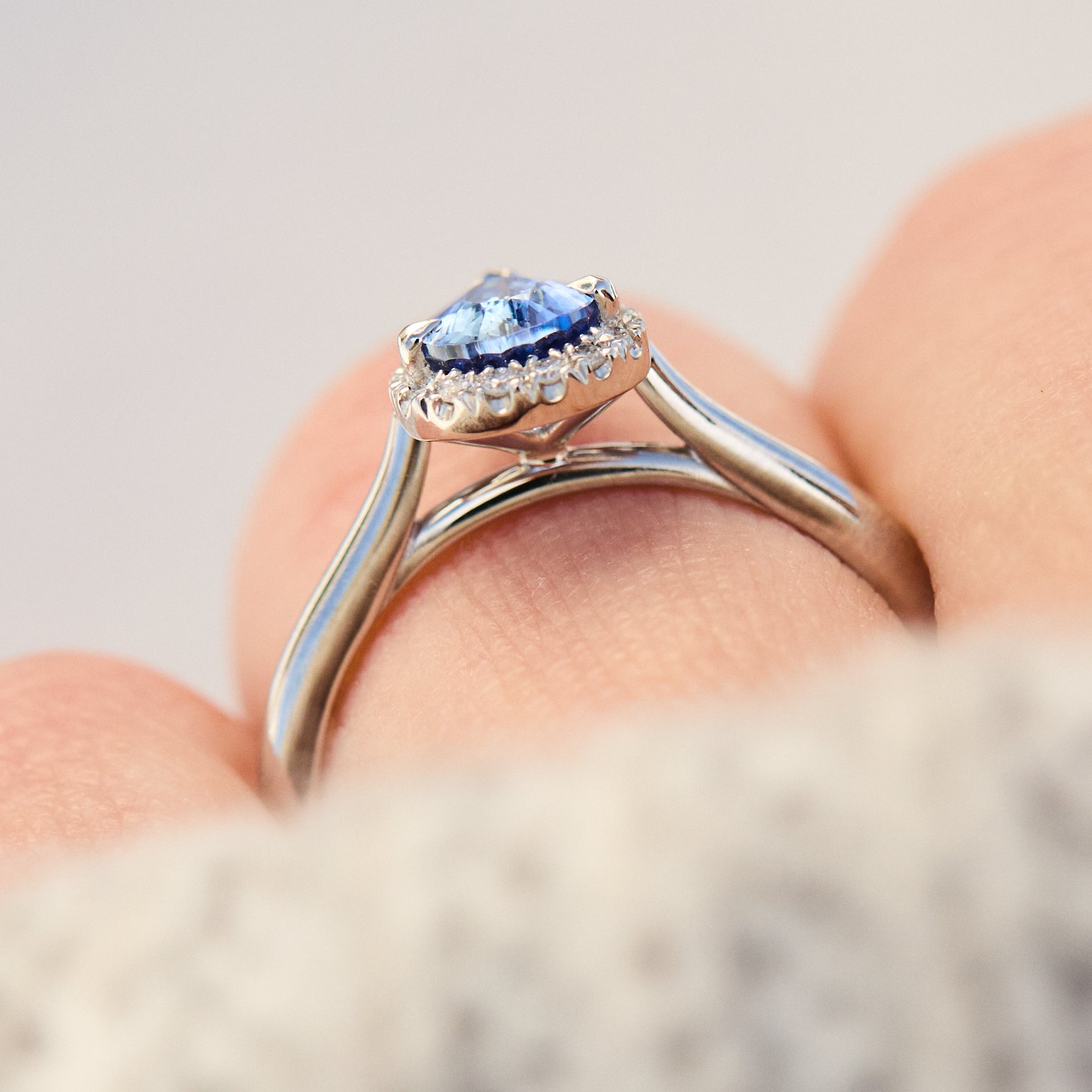 pear shape blue sapphire engagement ring with a pave diamond halo set in platinum
