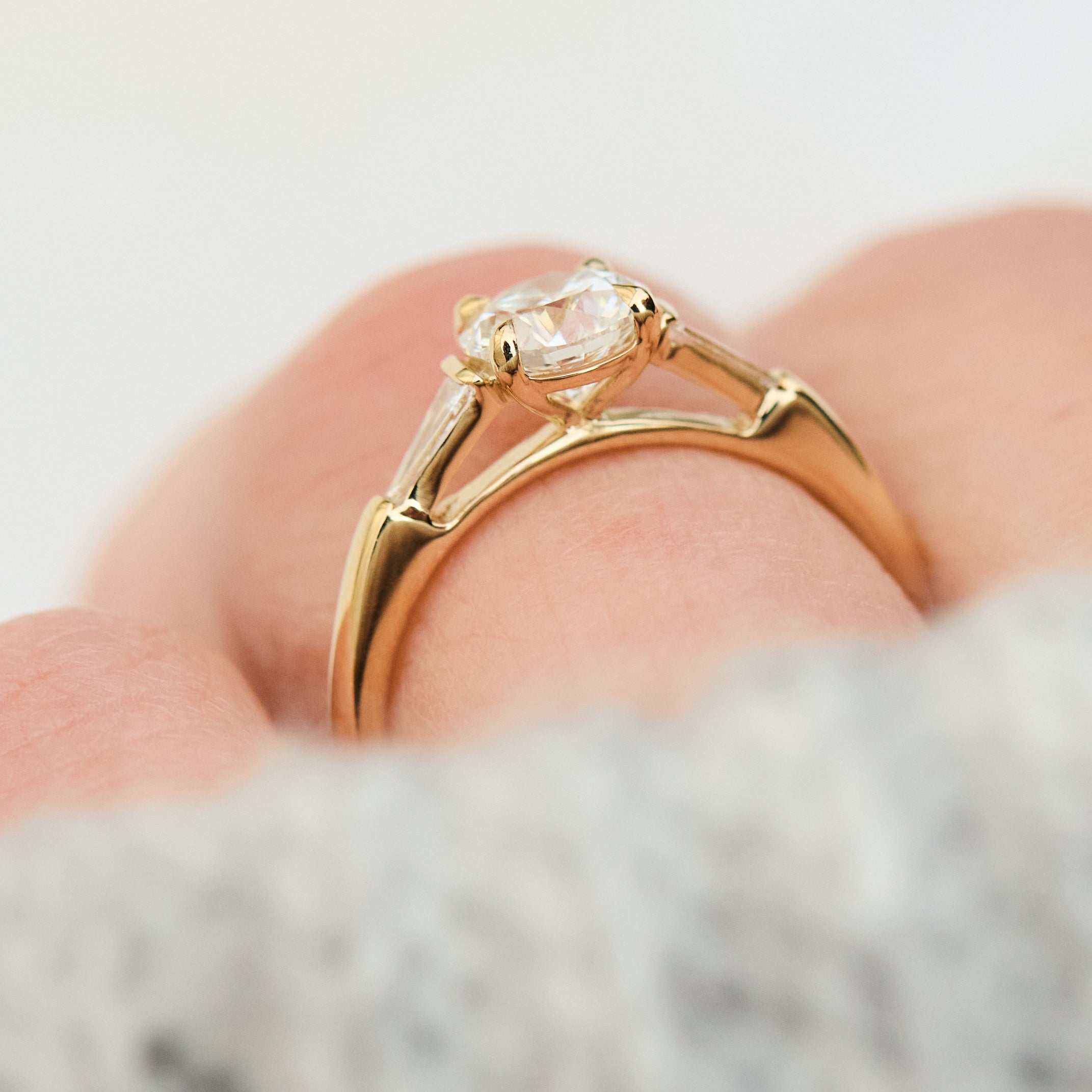 round brilliant cut diamond trilogy engagement ring with tapered baguette shoulders