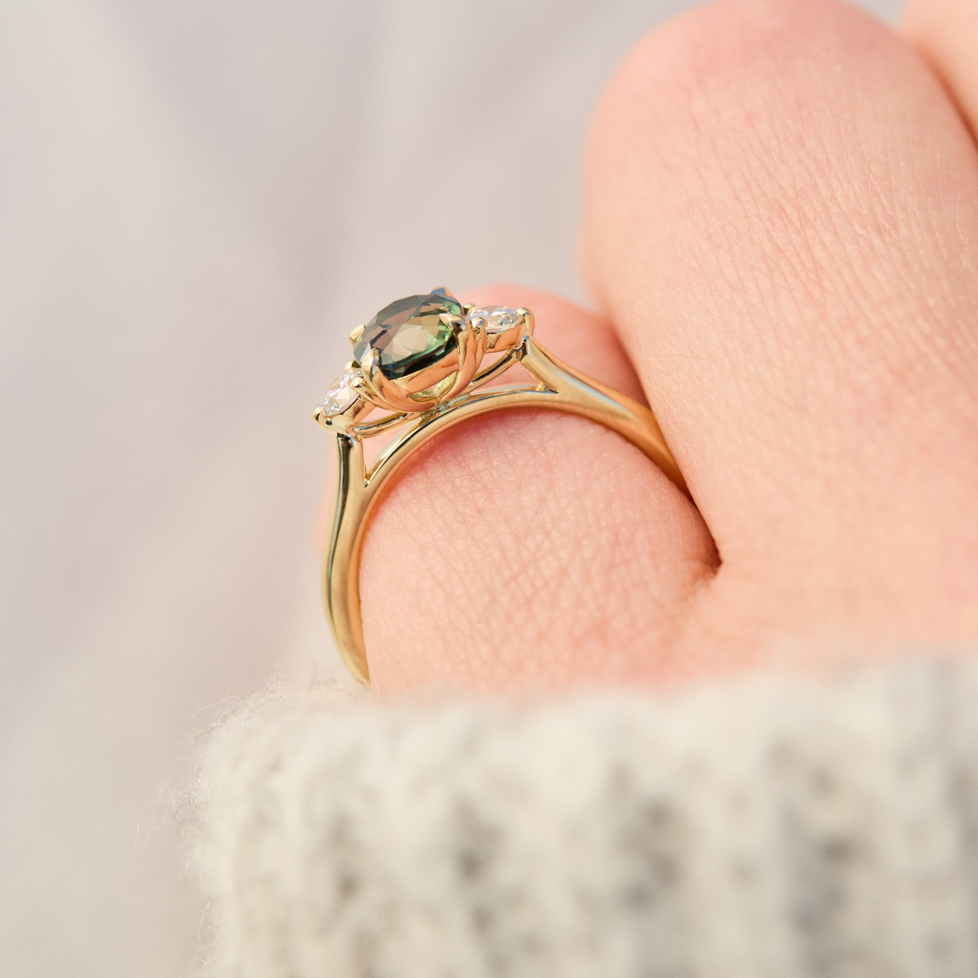 tanzanian oval teal sapphire trilogy engagement ring in yellow gold