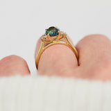 unheated teal blue oval sapphire engagement ring in yellow gold