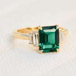 lab grown emerald and diamonds engagement ring set in yellow gold
