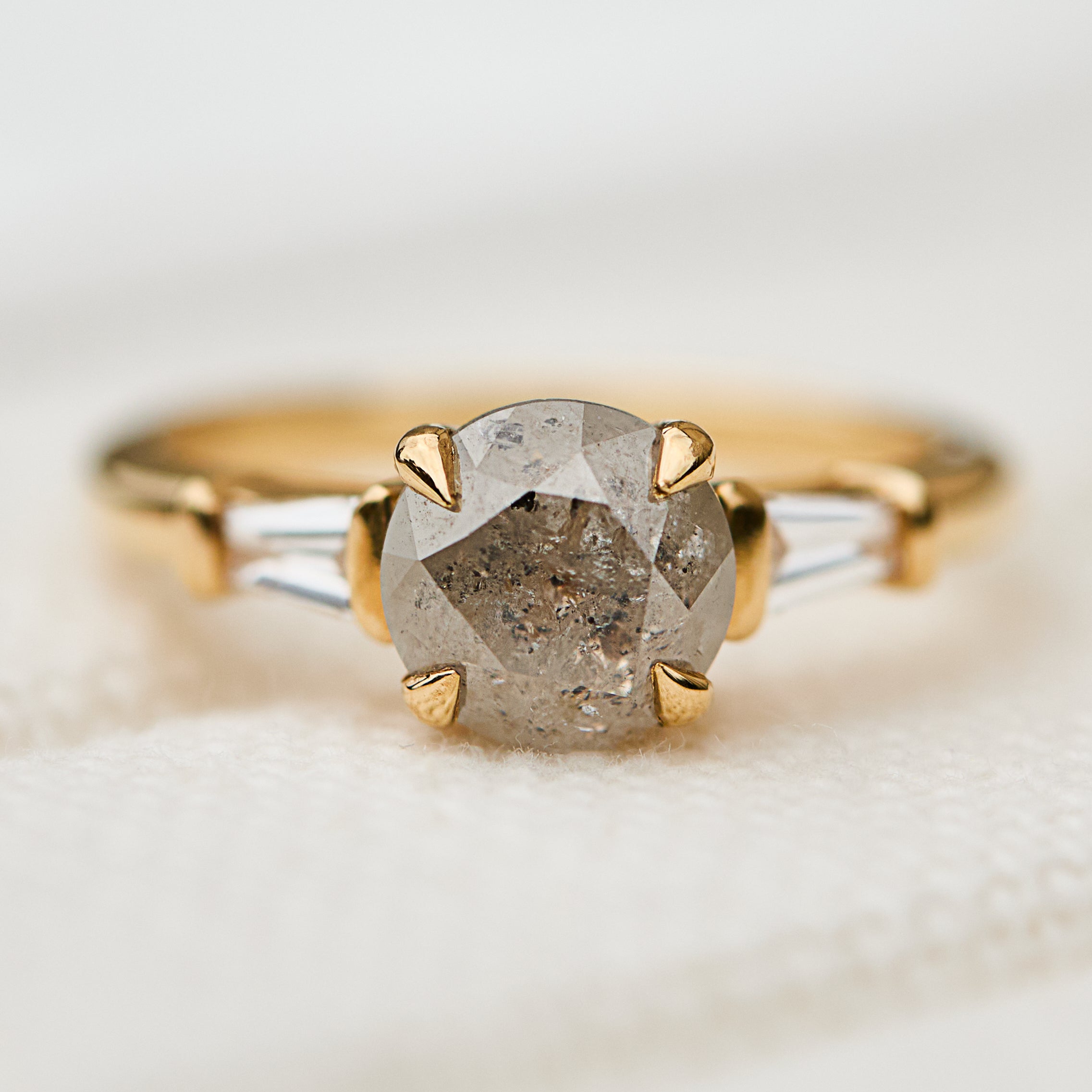 light grey round salt and pepper diamond trilogy engagement ring in yellow gold