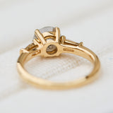 light grey round salt and pepper diamond trilogy engagement ring in yellow gold