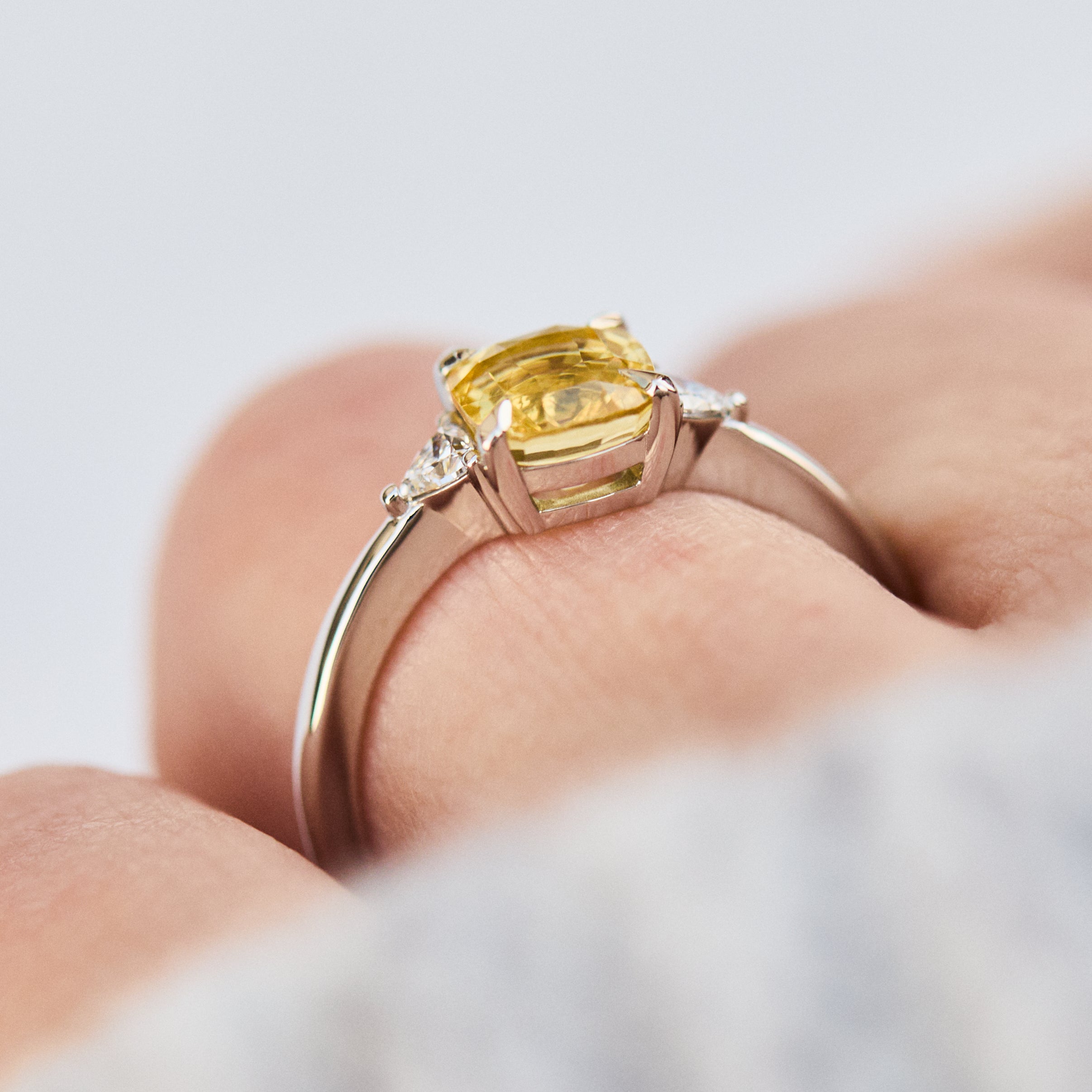 cushion cut yellow sapphire trilogy engagement ring in platinum