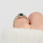 oval teal sapphire engagement ring set in platinum accented by six side diamonds