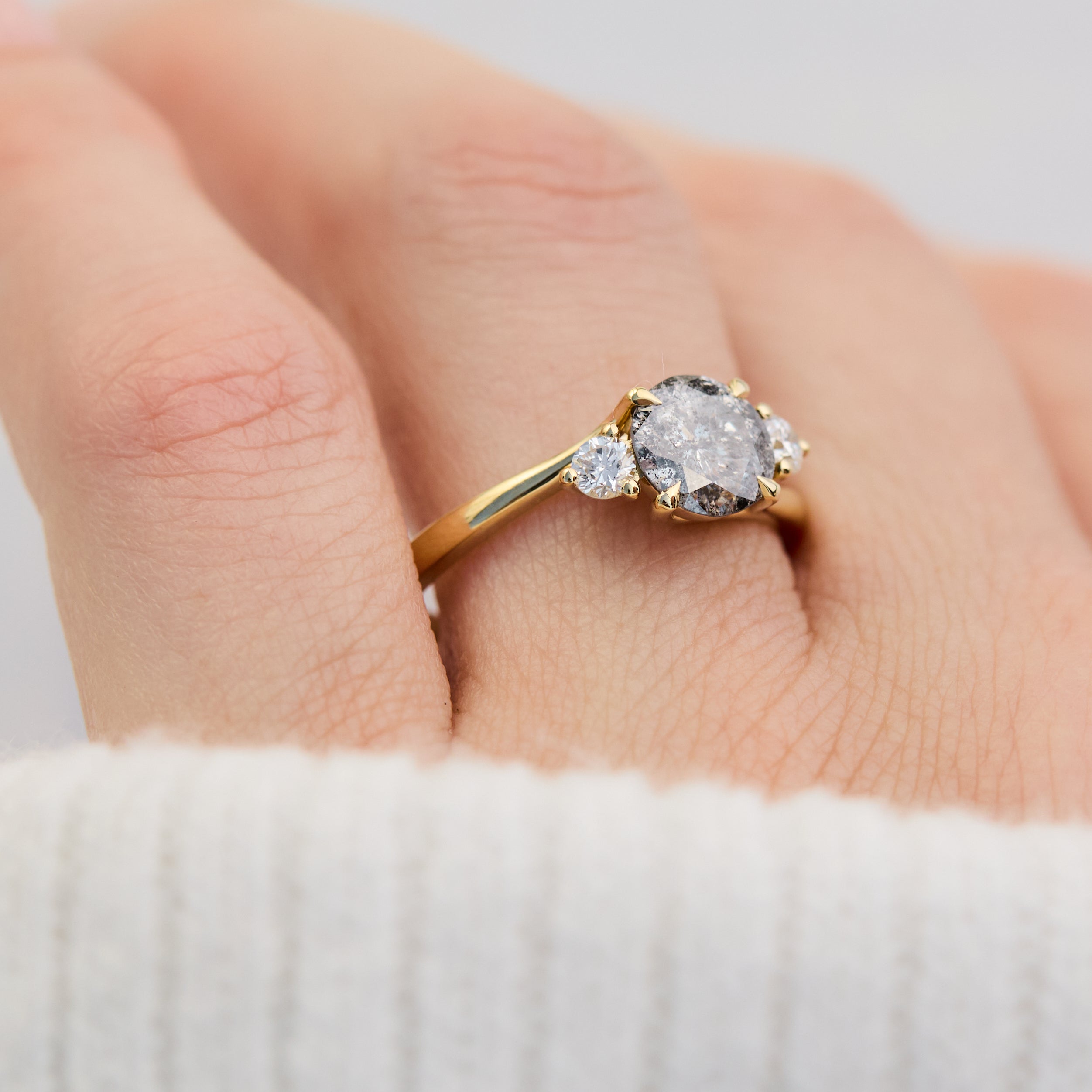 round salt and pepper diamond trilogy engagement ring in yellow gold