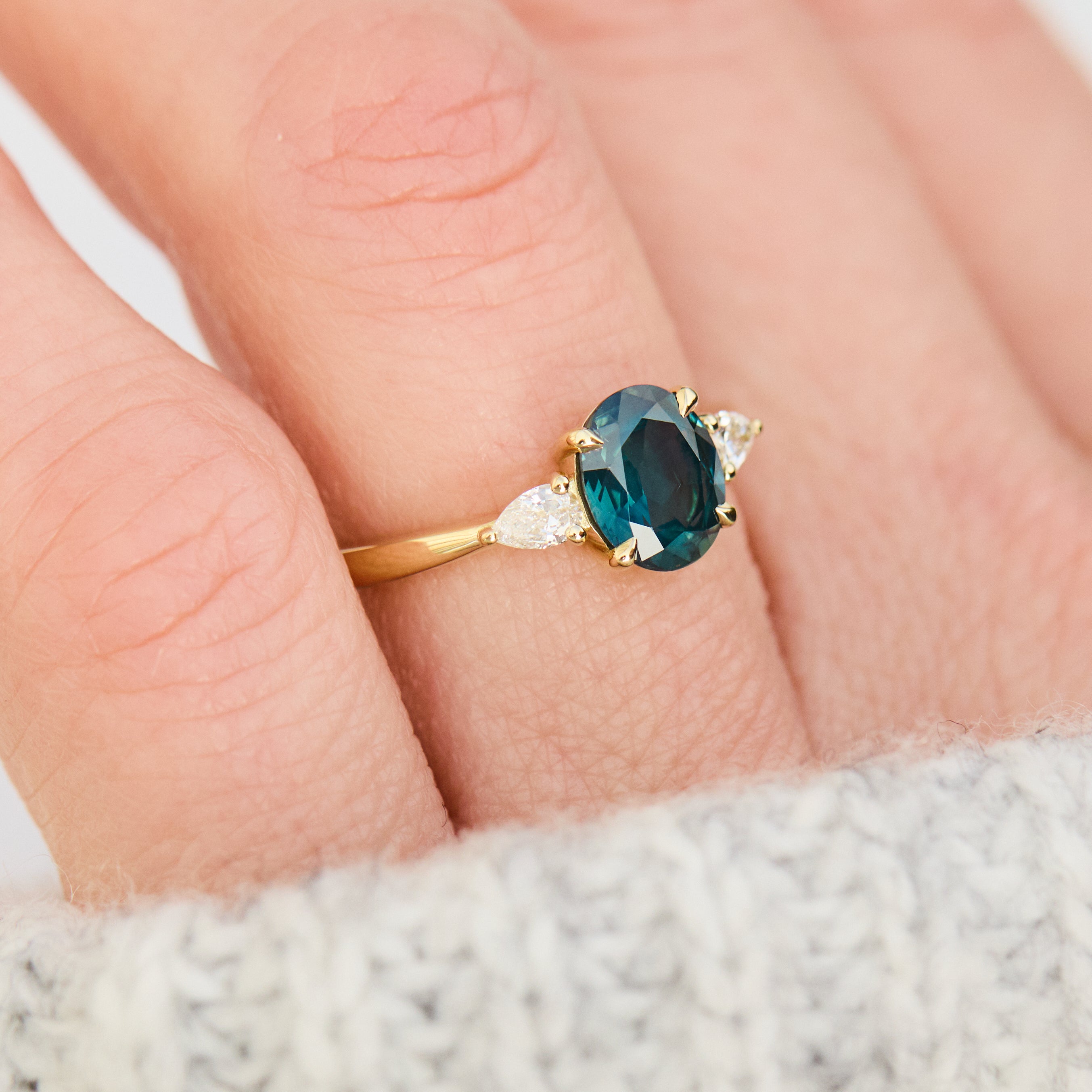 oval australian teal sapphire trilogy engagement ring in yellow gold