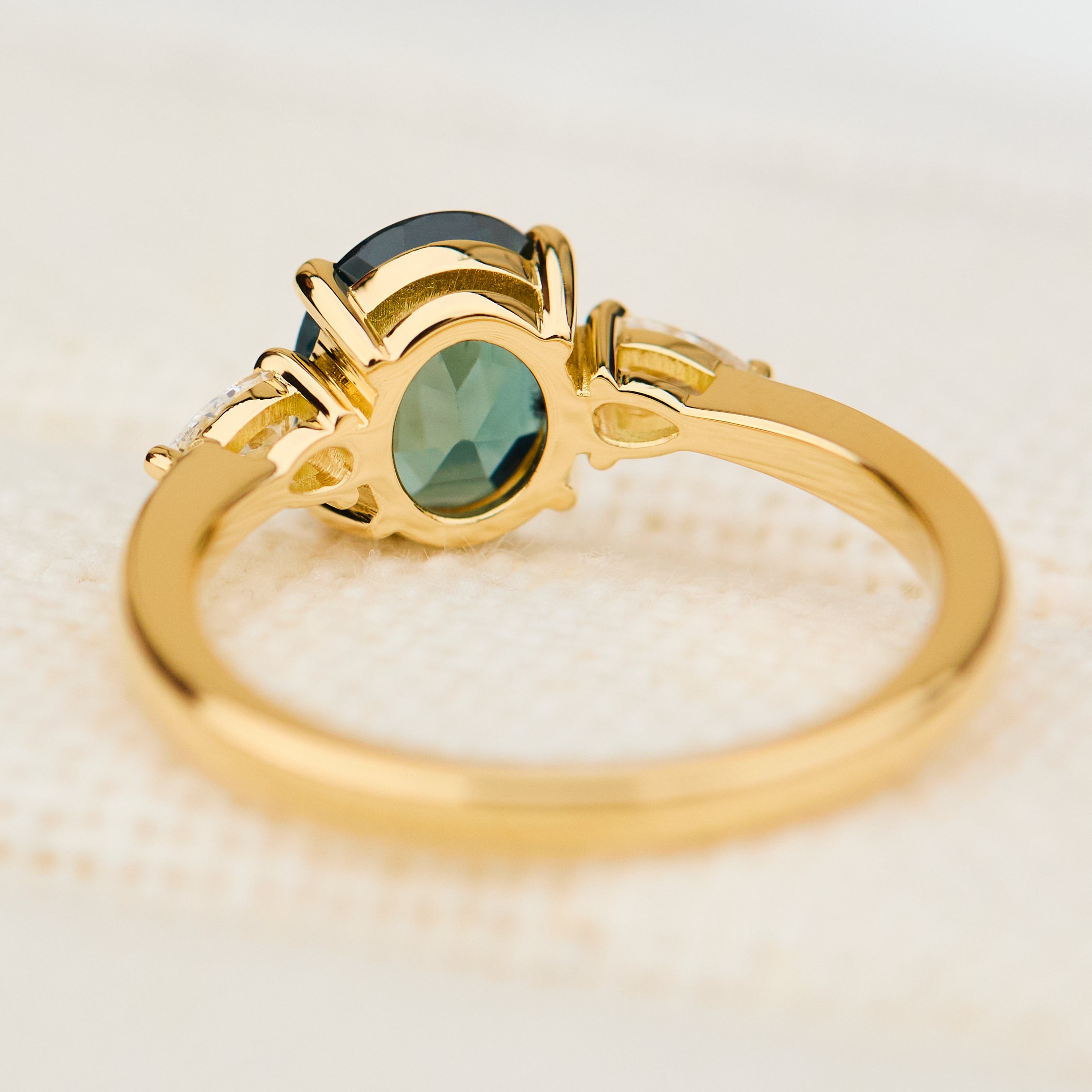 oval australian teal sapphire trilogy engagement ring in yellow gold