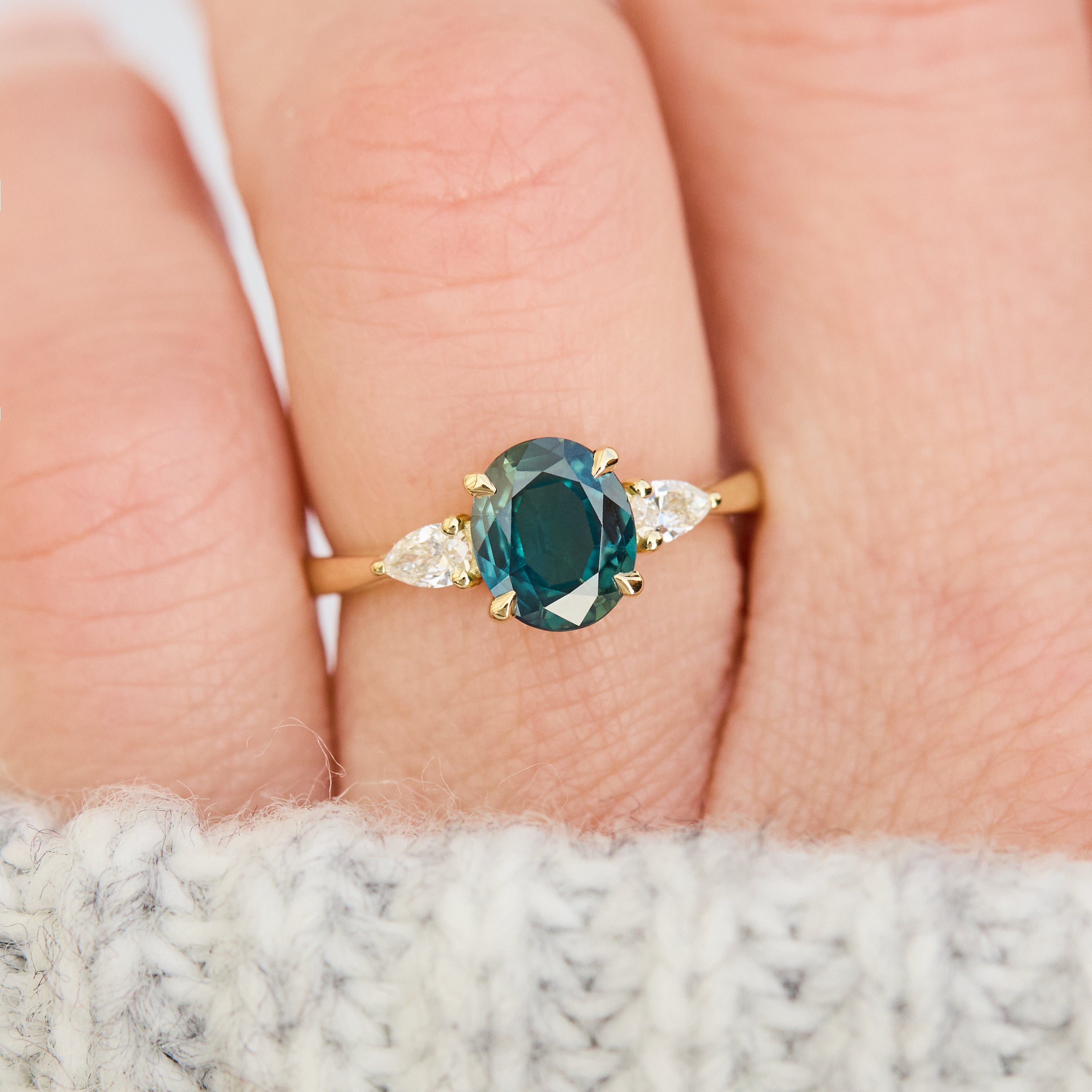 oval australian teal sapphire trilogy engagement ring in yellow gold