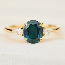 oval australian teal sapphire trilogy engagement ring in yellow gold