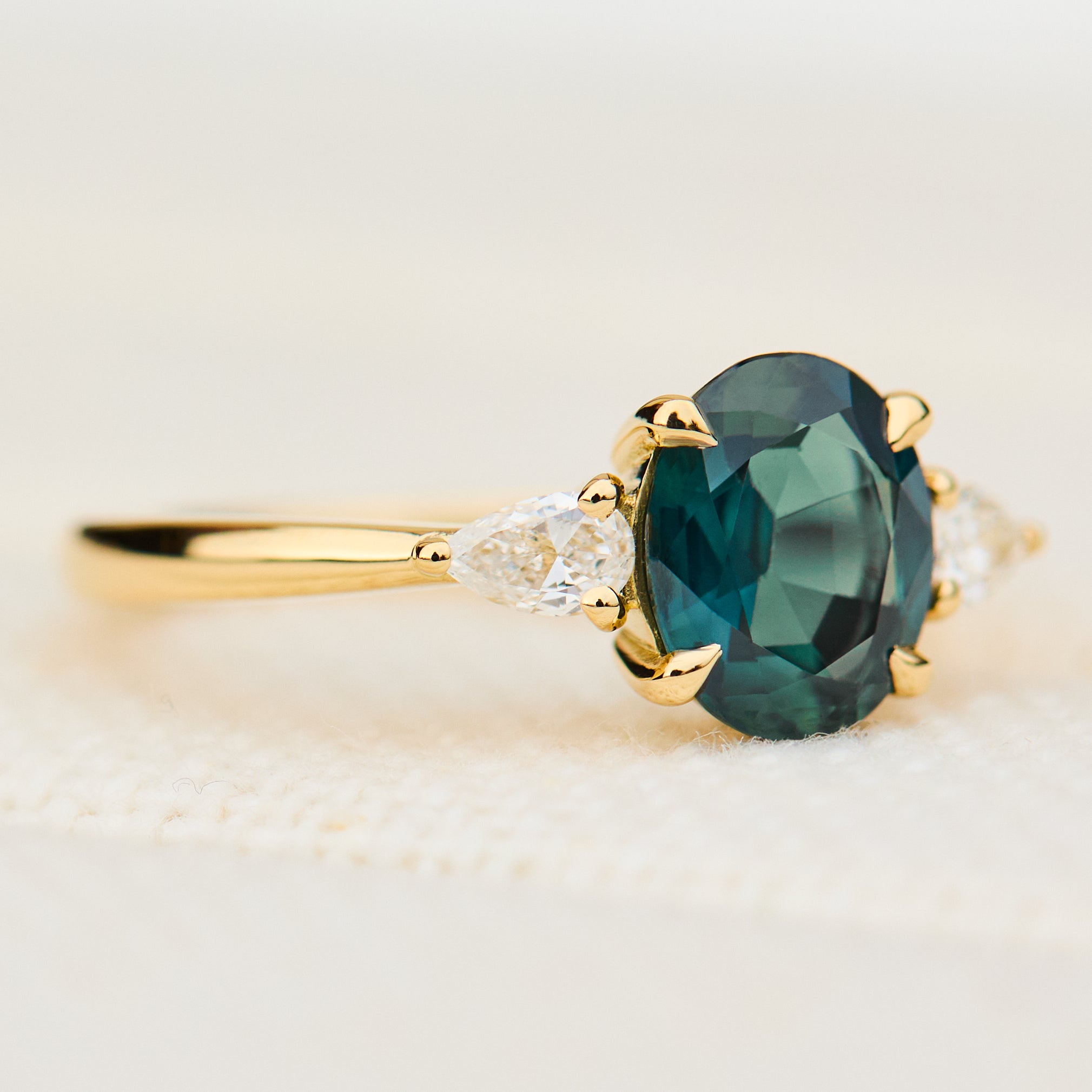 oval australian teal sapphire trilogy engagement ring in yellow gold