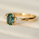 oval blue teal montana sapphire engagement ring in yellow gold