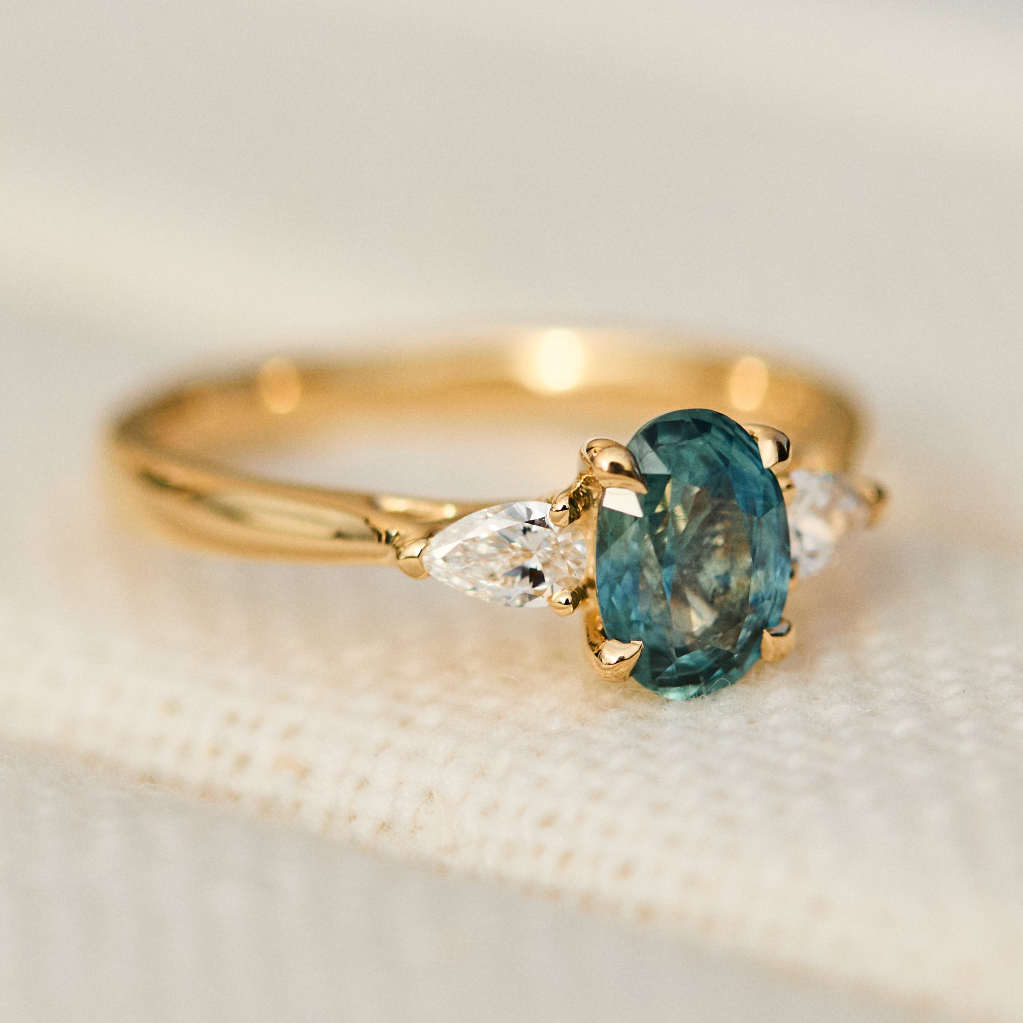 oval blue teal montana sapphire engagement ring in yellow gold
