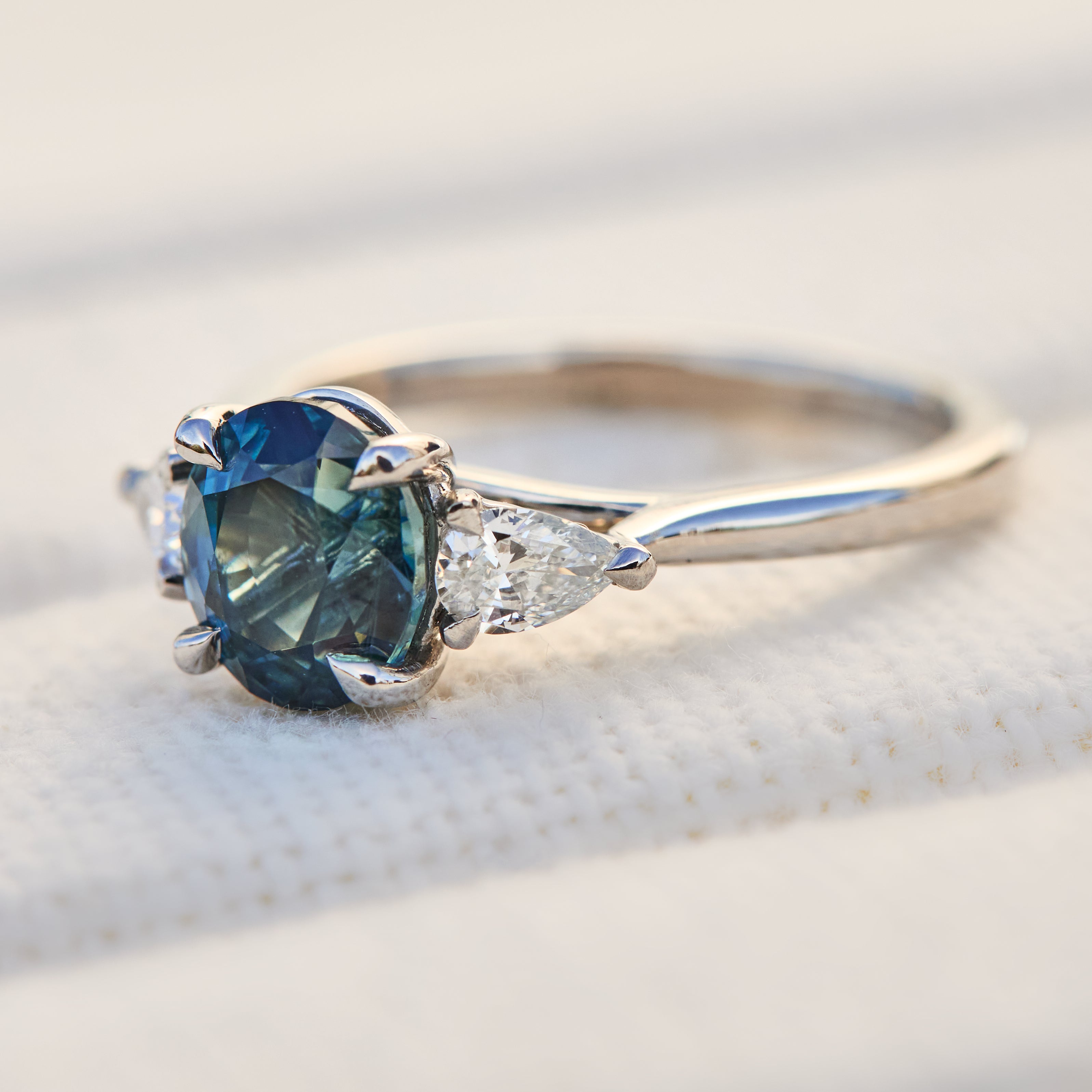 oval blue teal sapphire platinum trilogy engagement ring