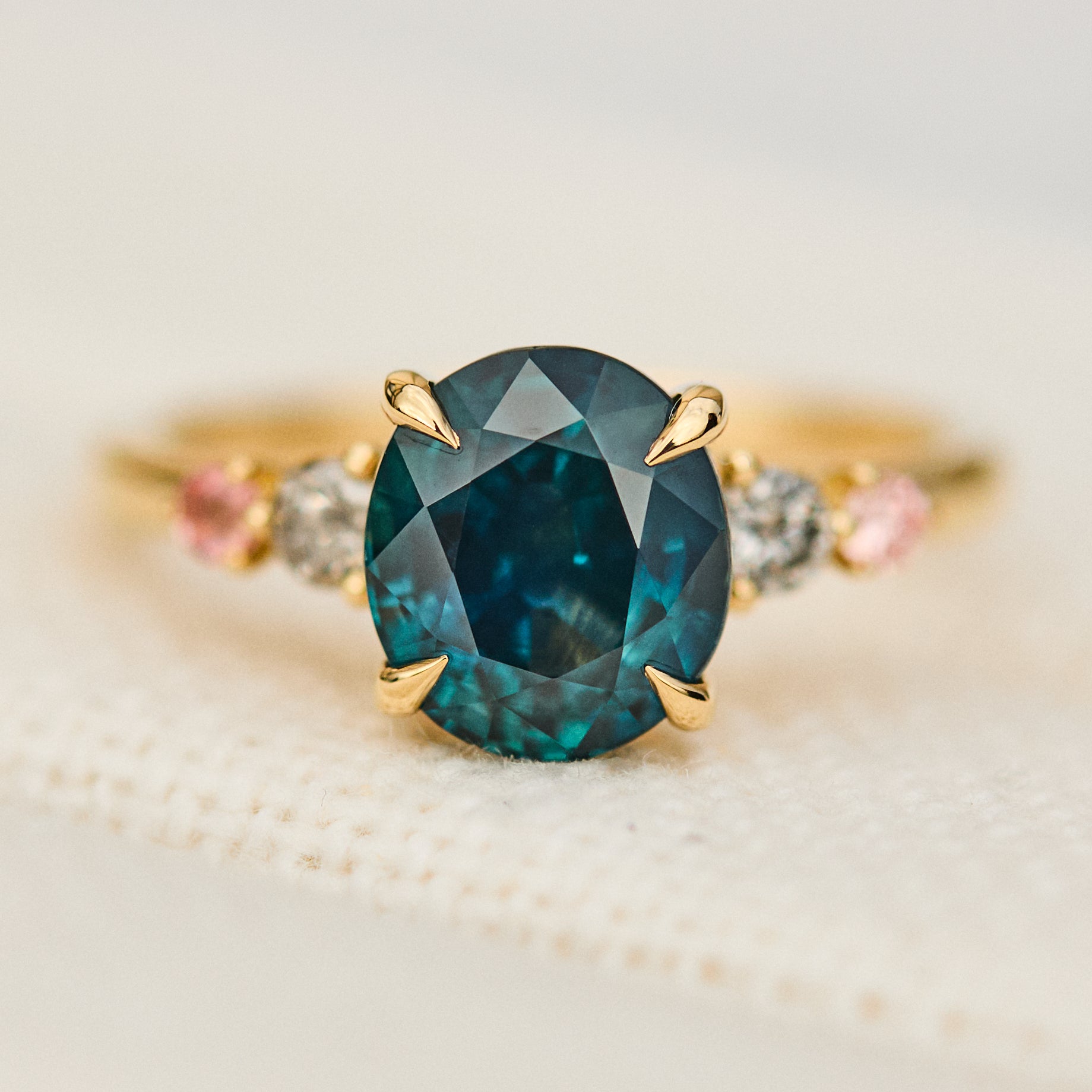 oval blue teal sapphire yellow gold engagement ring with four side stones