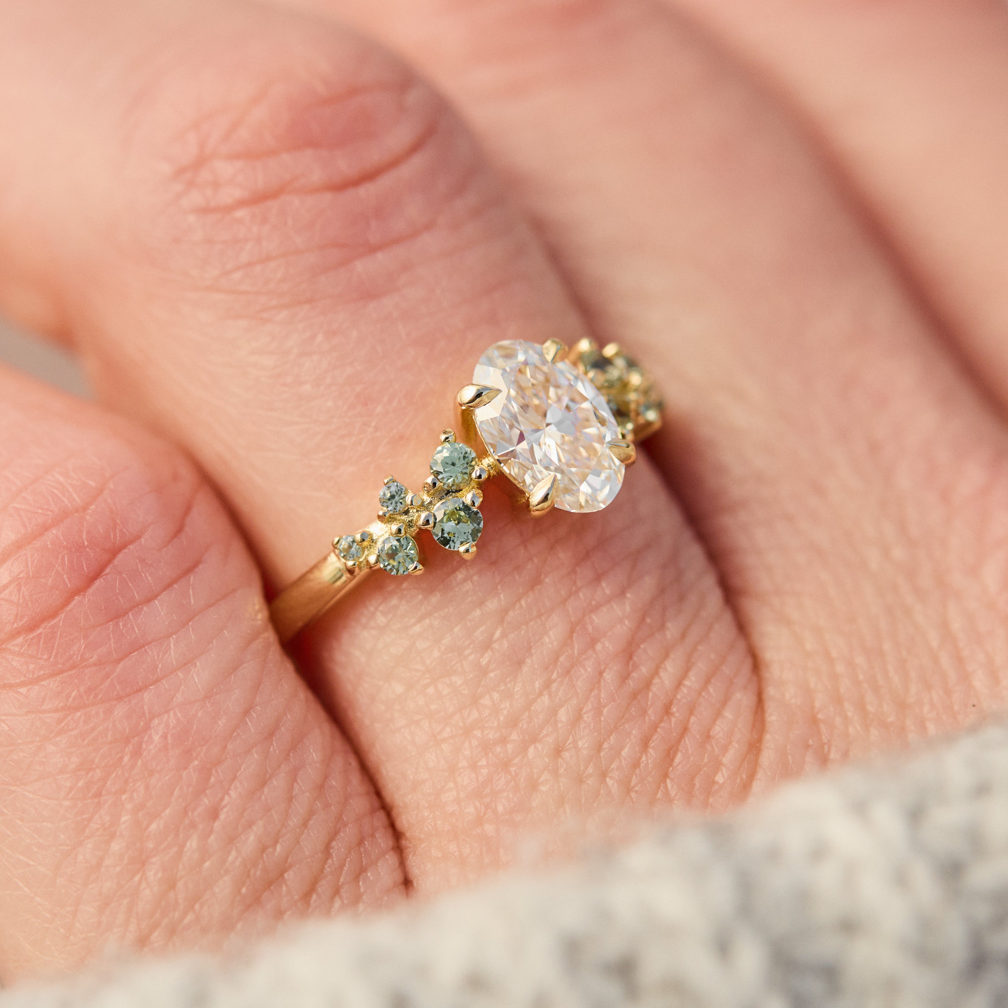 oval diamond engagement ring flanked by ten round side diamonds set in yellow gold