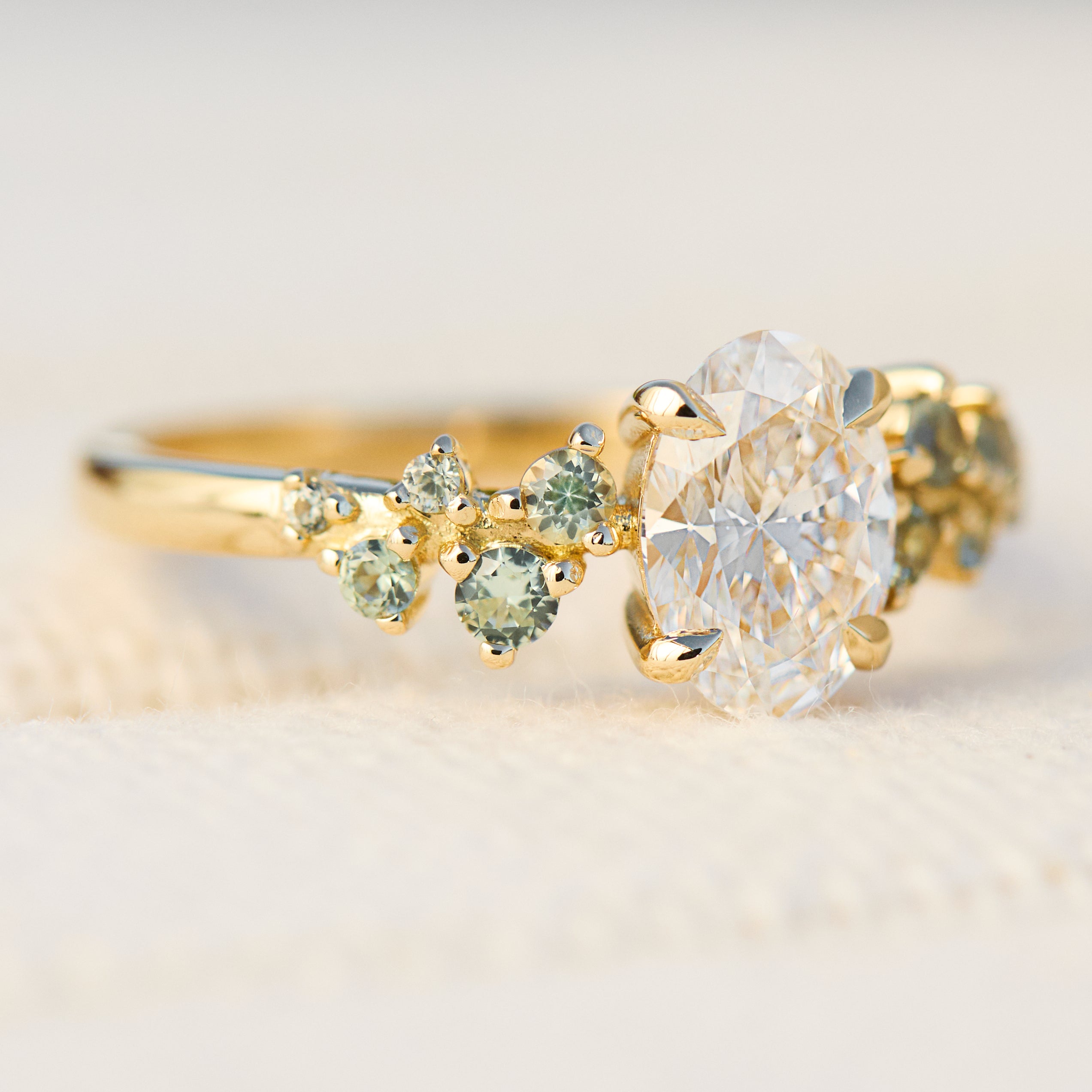 oval diamond engagement ring flanked by ten round side diamonds set in yellow gold