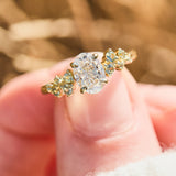 oval diamond engagement ring flanked by ten round side diamonds set in yellow gold