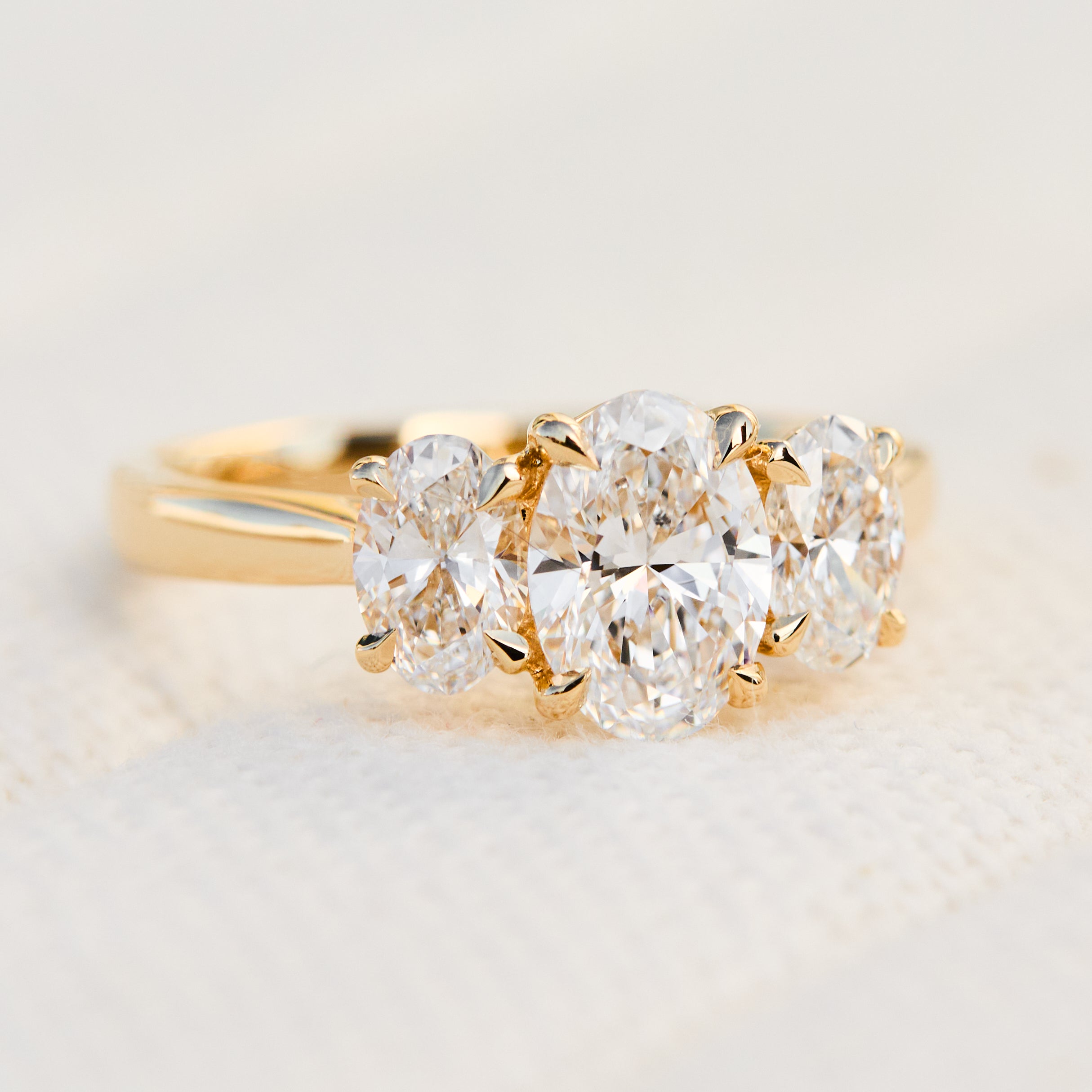 oval diamonds trilogy engagement ring set in 18ct yellow gold