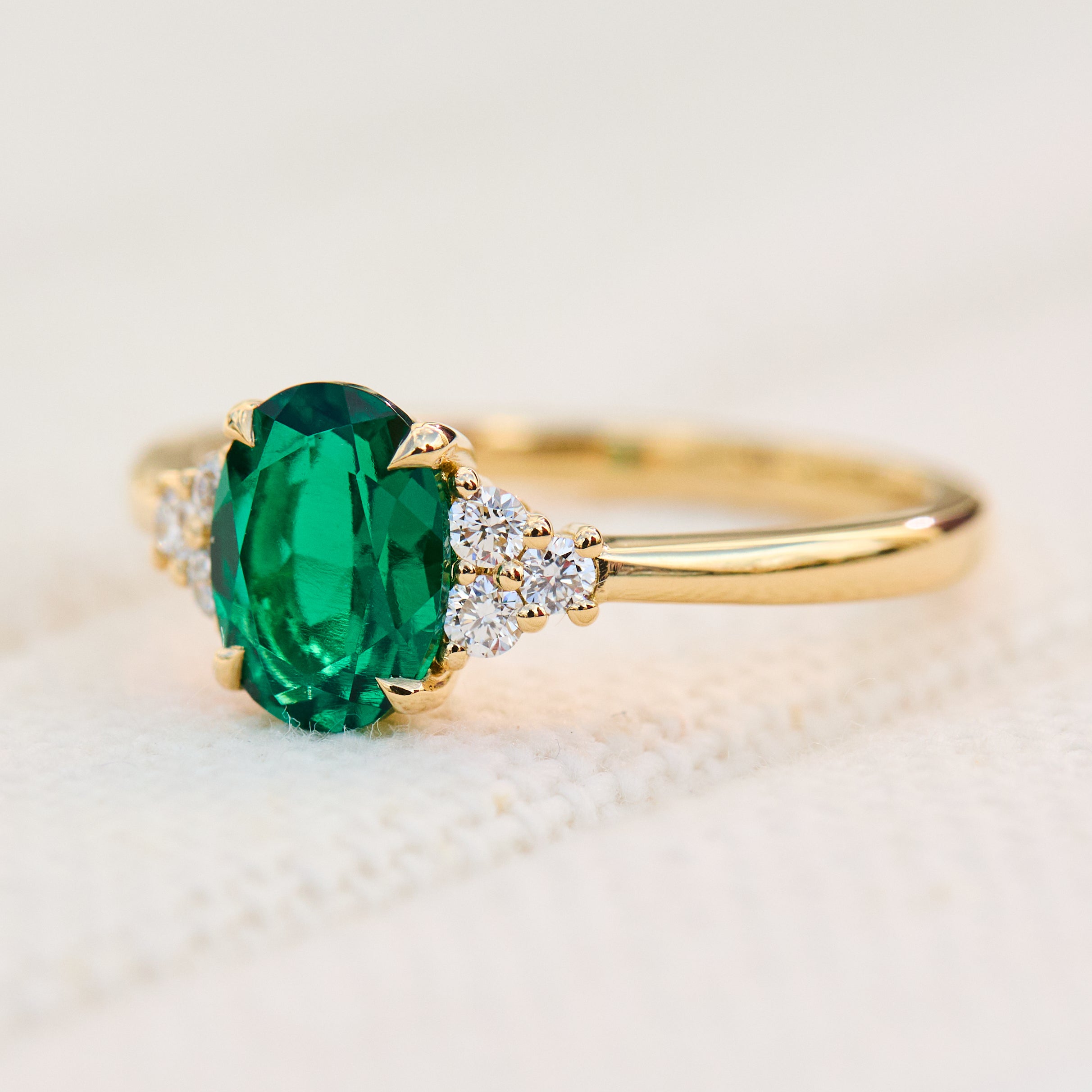 oval emerald yellow gold engagement ring with six round side diamonds