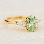 oval green lab grown diamond trilogy engagement ring in yellow gold