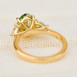oval green lab grown diamond trilogy engagement ring in yellow gold