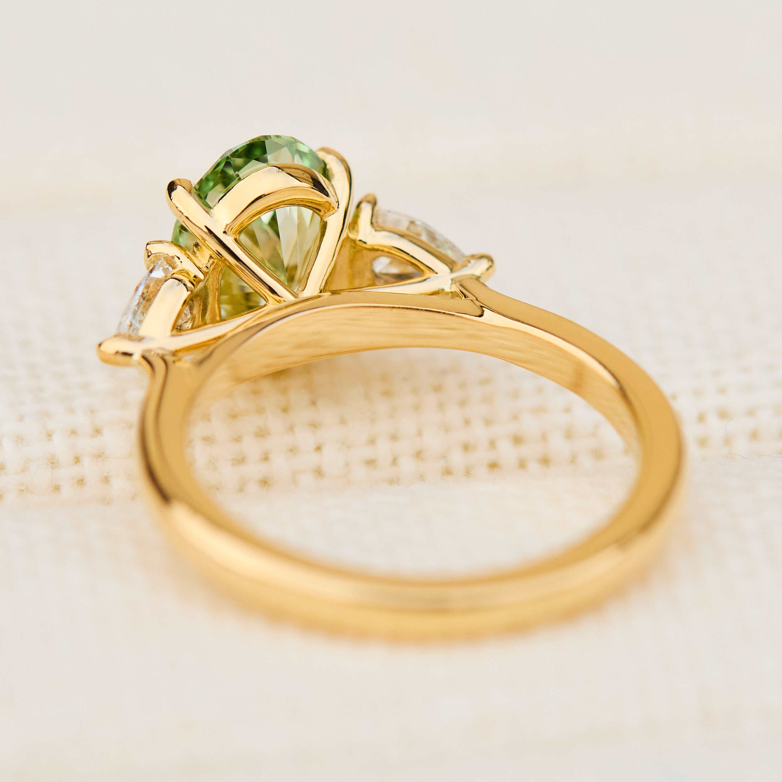 oval green lab grown diamond trilogy engagement ring in yellow gold