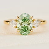 oval green lab grown diamond trilogy engagement ring in yellow gold