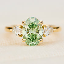 oval green lab grown diamond trilogy engagement ring in yellow gold