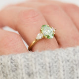 oval green lab grown diamond trilogy engagement ring in yellow gold