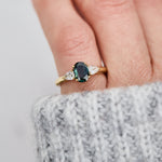oval green sapphire trilogy engagement ring in yellow gold