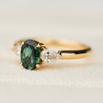 oval green sapphire trilogy engagement ring in yellow gold