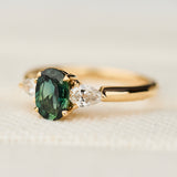 oval green sapphire trilogy engagement ring in yellow gold