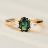 oval green sapphire trilogy engagement ring in yellow gold
