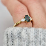 oval green sapphire trilogy engagement ring in yellow gold