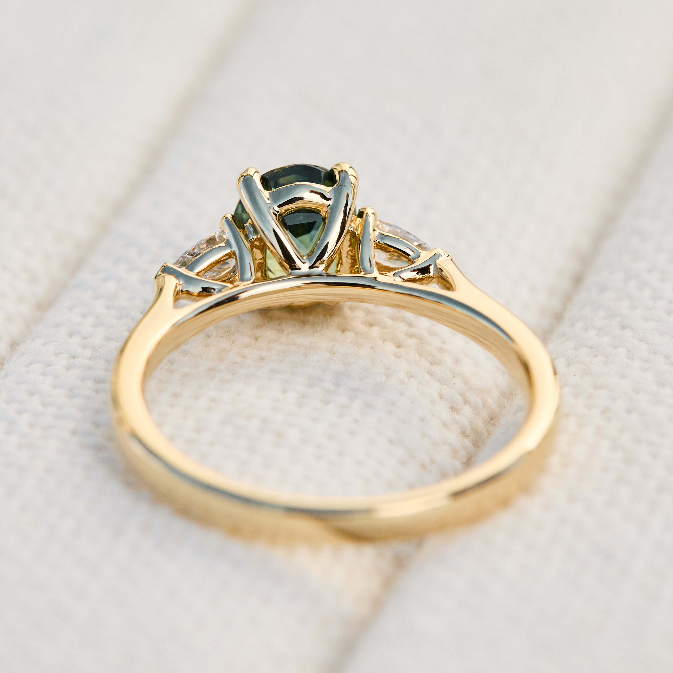 oval green teal sapphire trilogy engagement ring set in 18ct yellow gold