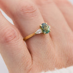 oval green teal sapphire trilogy engagement ring set in 18ct yellow gold