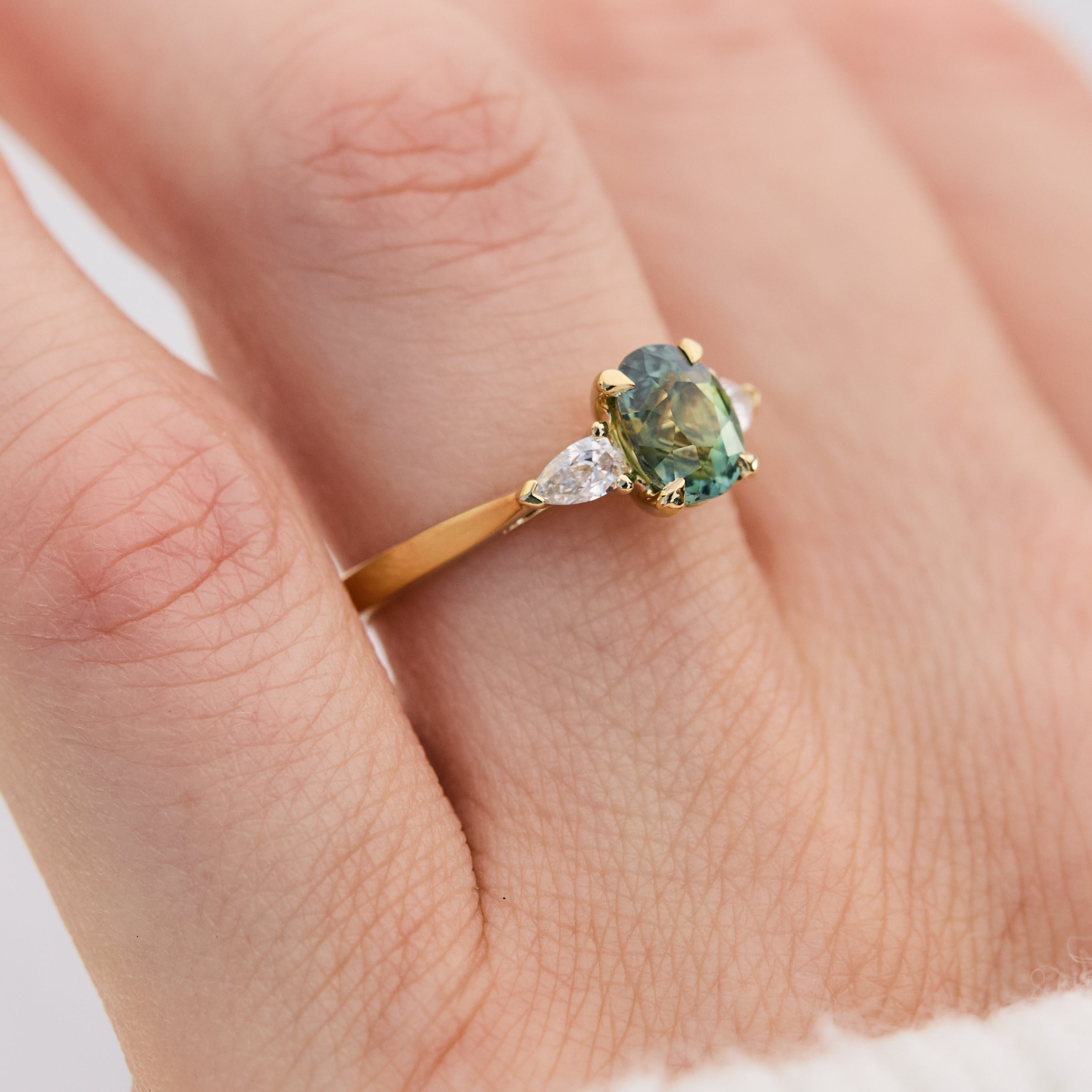 oval green teal sapphire trilogy engagement ring set in 18ct yellow gold