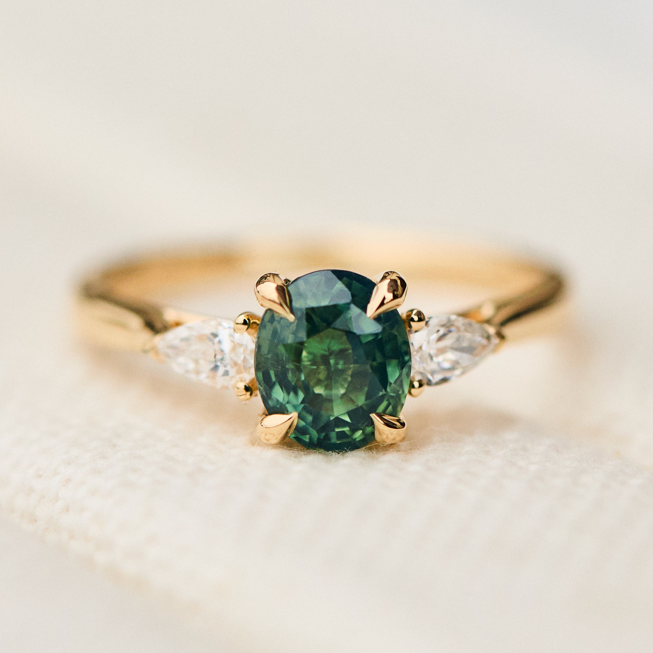 oval green teal sapphire trilogy engagement ring in yellow gold
